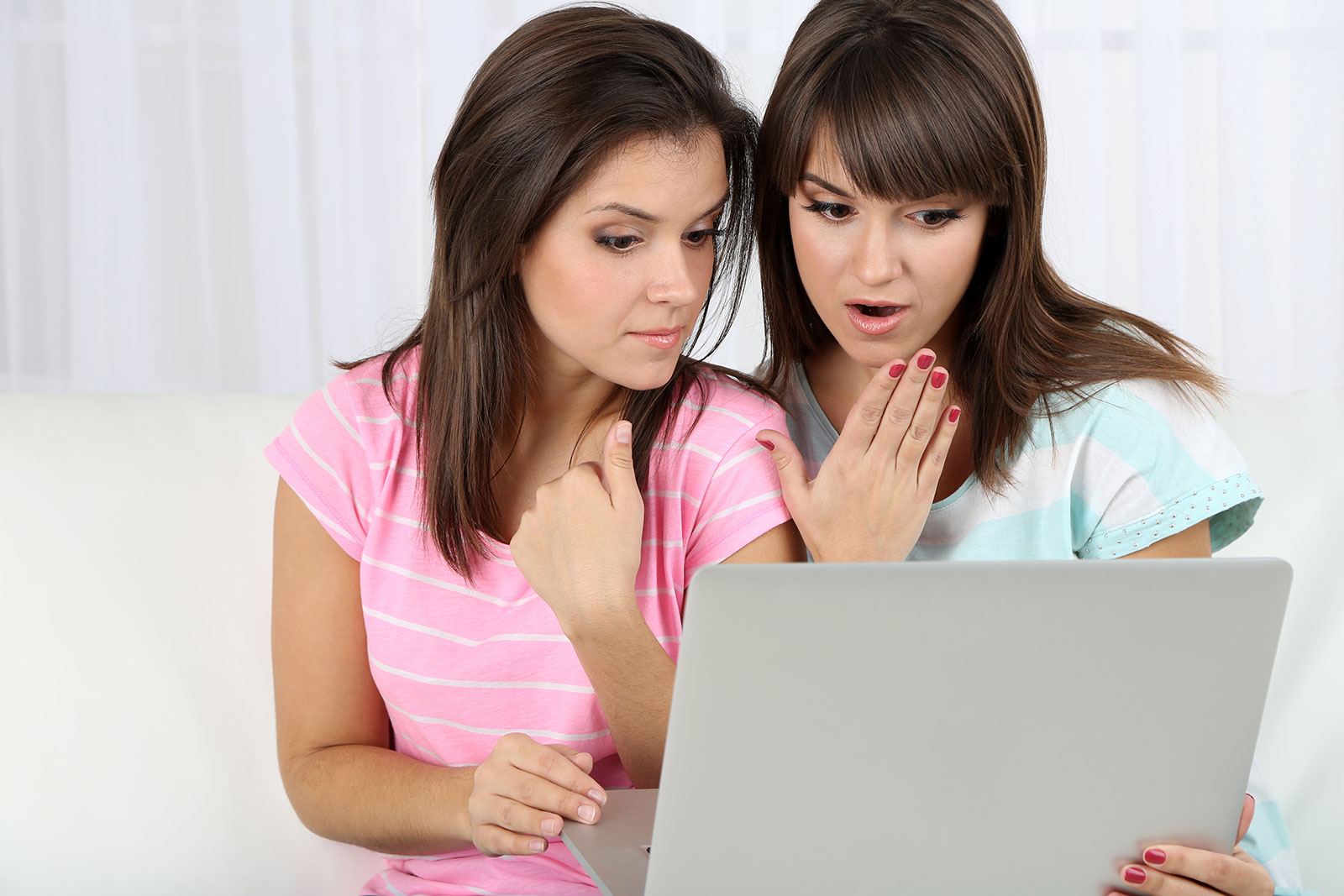 Twin siblings looking upset at a mixed credit file on a computer